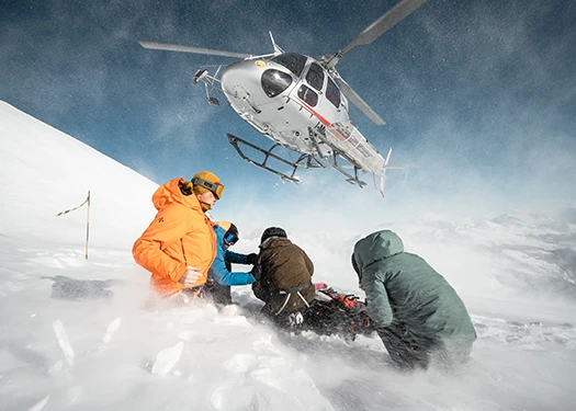 Groupe de skieurs regardant un hélicoptère s’envoler